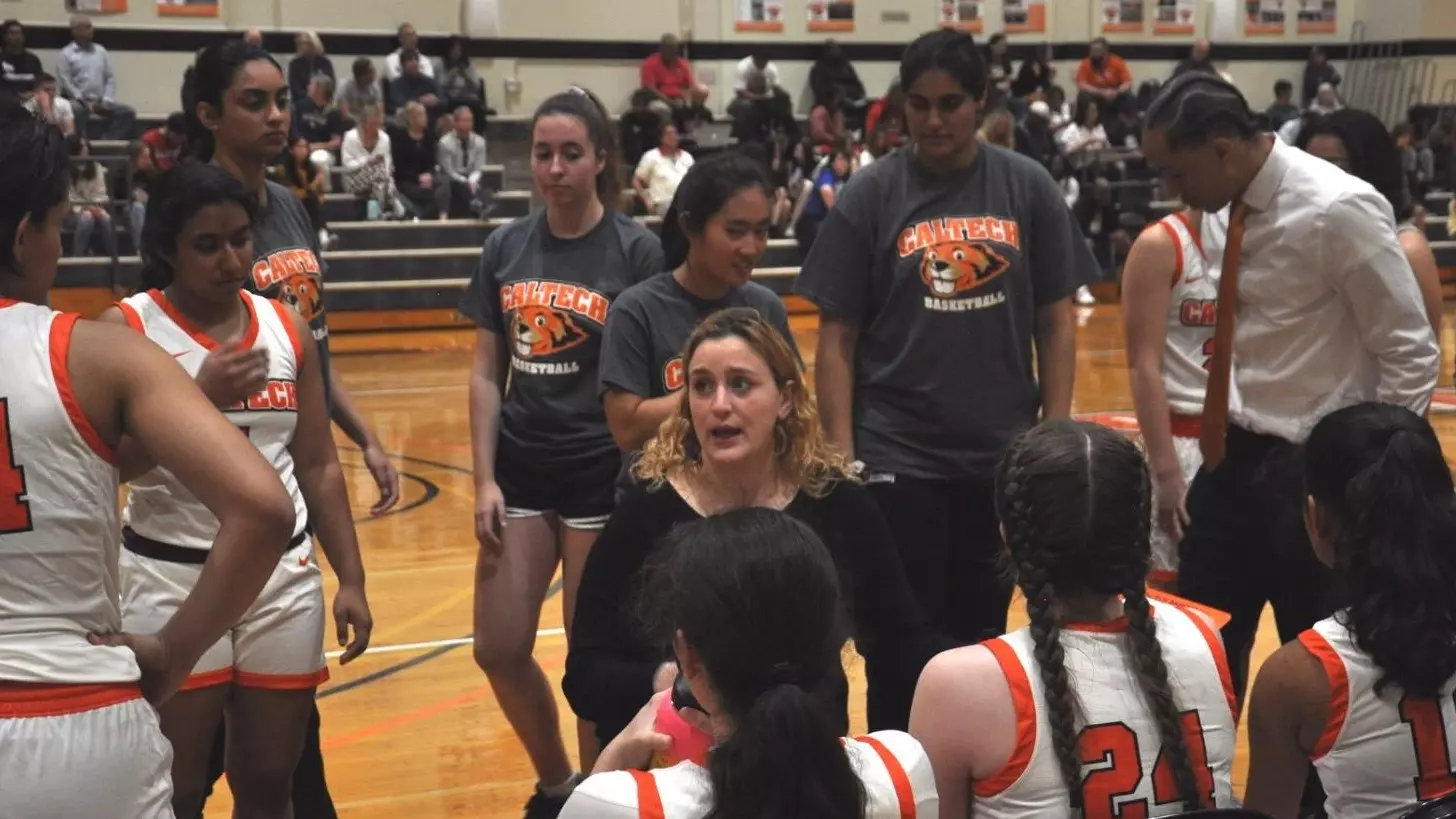 Annie Tarakchian discusses strategy with Caltech Women's Basketball players during a timeout