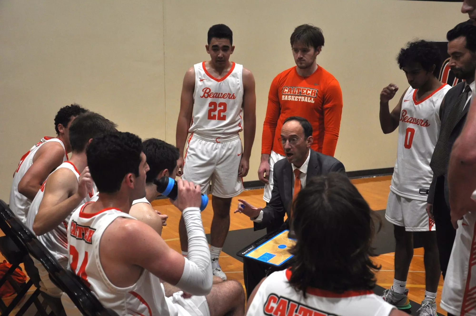 Coach Eslinger talks with Caltech Men's Basketball players during a timeout