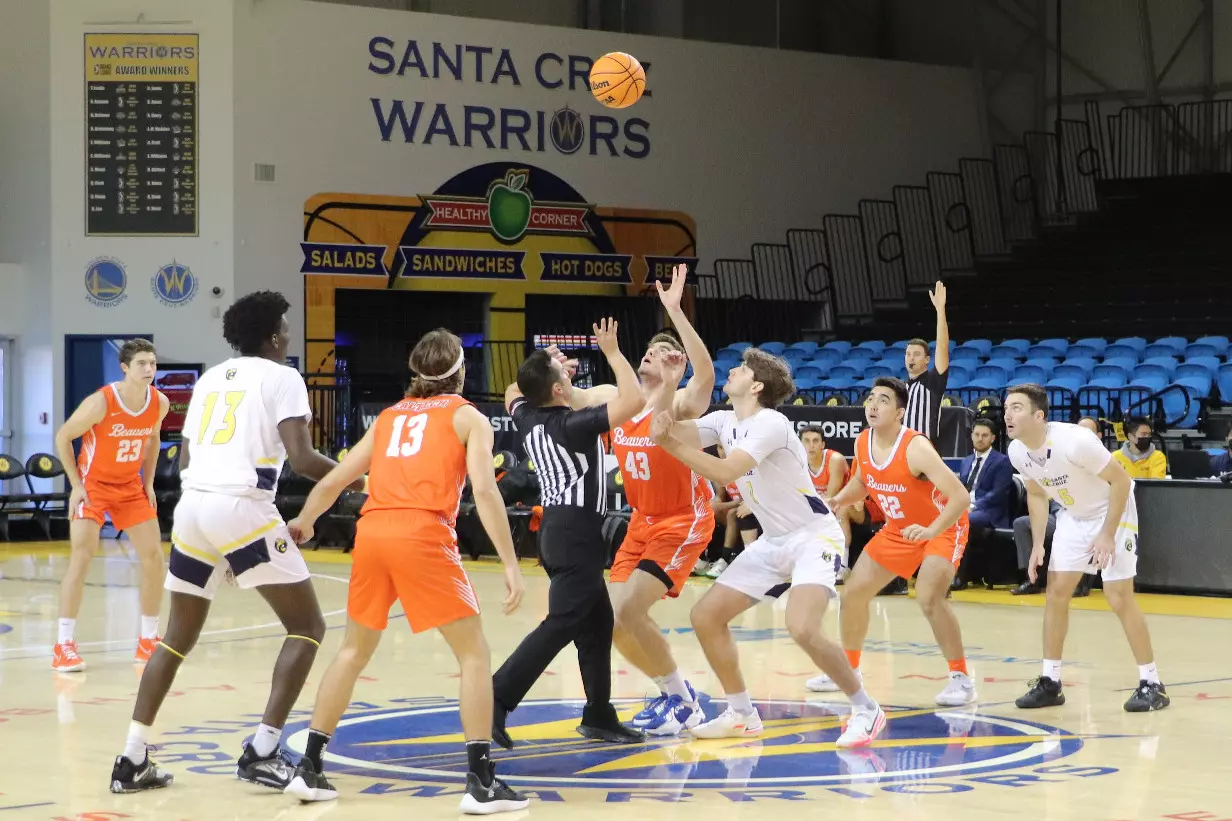 The referee throws the basketball in the air for the tip-off of the Caltech at UC Santa Cruz game
