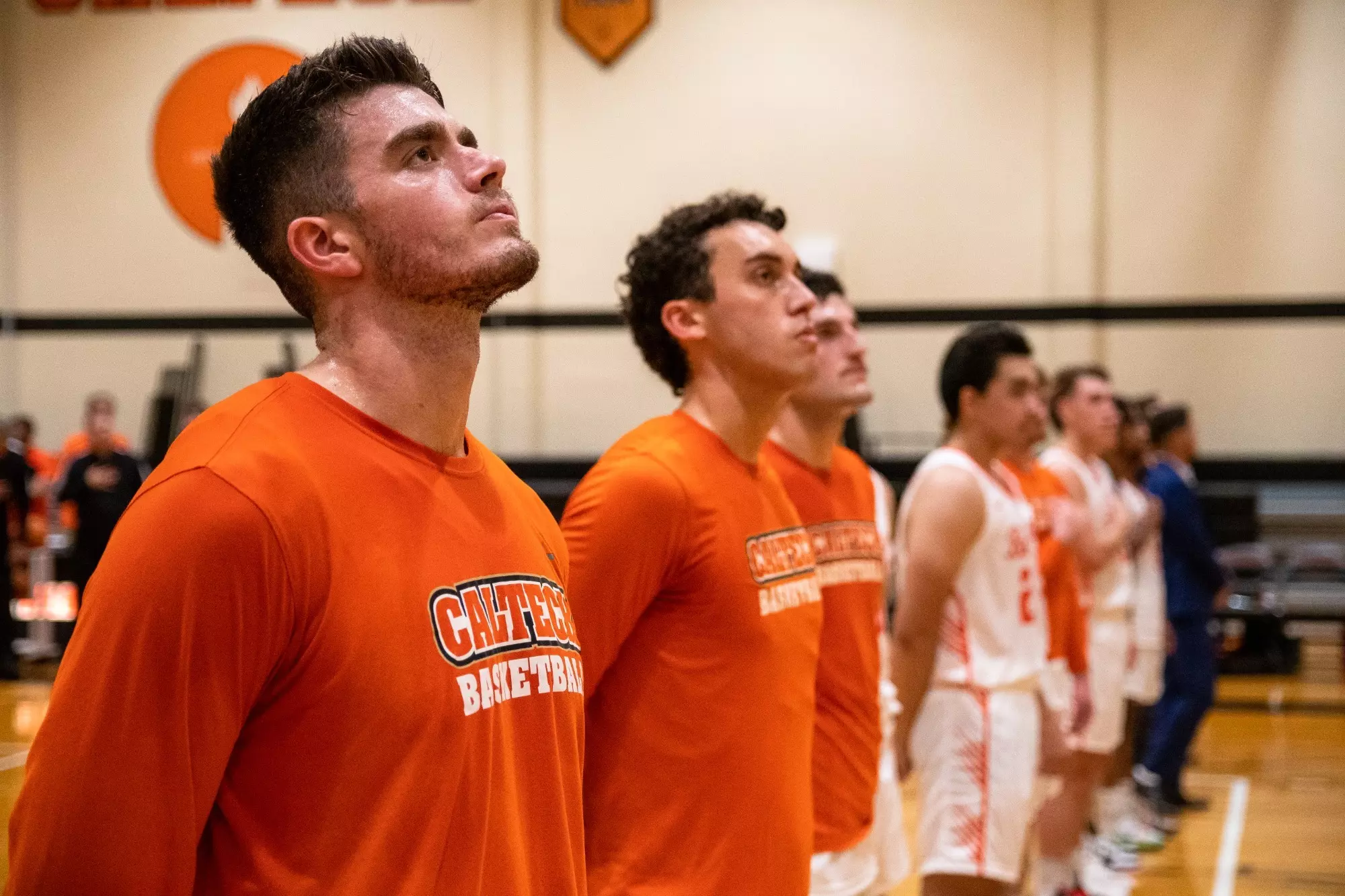 Caltech Men's Basketball players stand in line during pregame