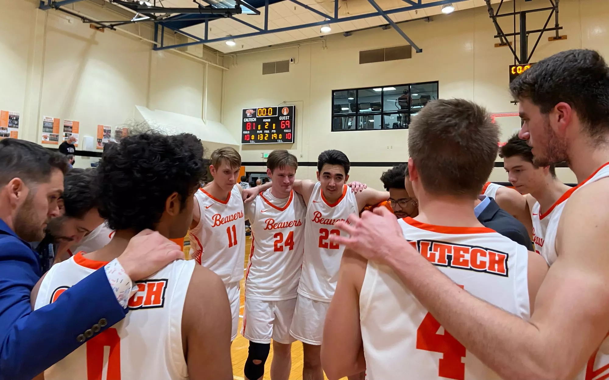 Caltech Men's Basketball players huddle at half court after a 81-69 home win over Whittier