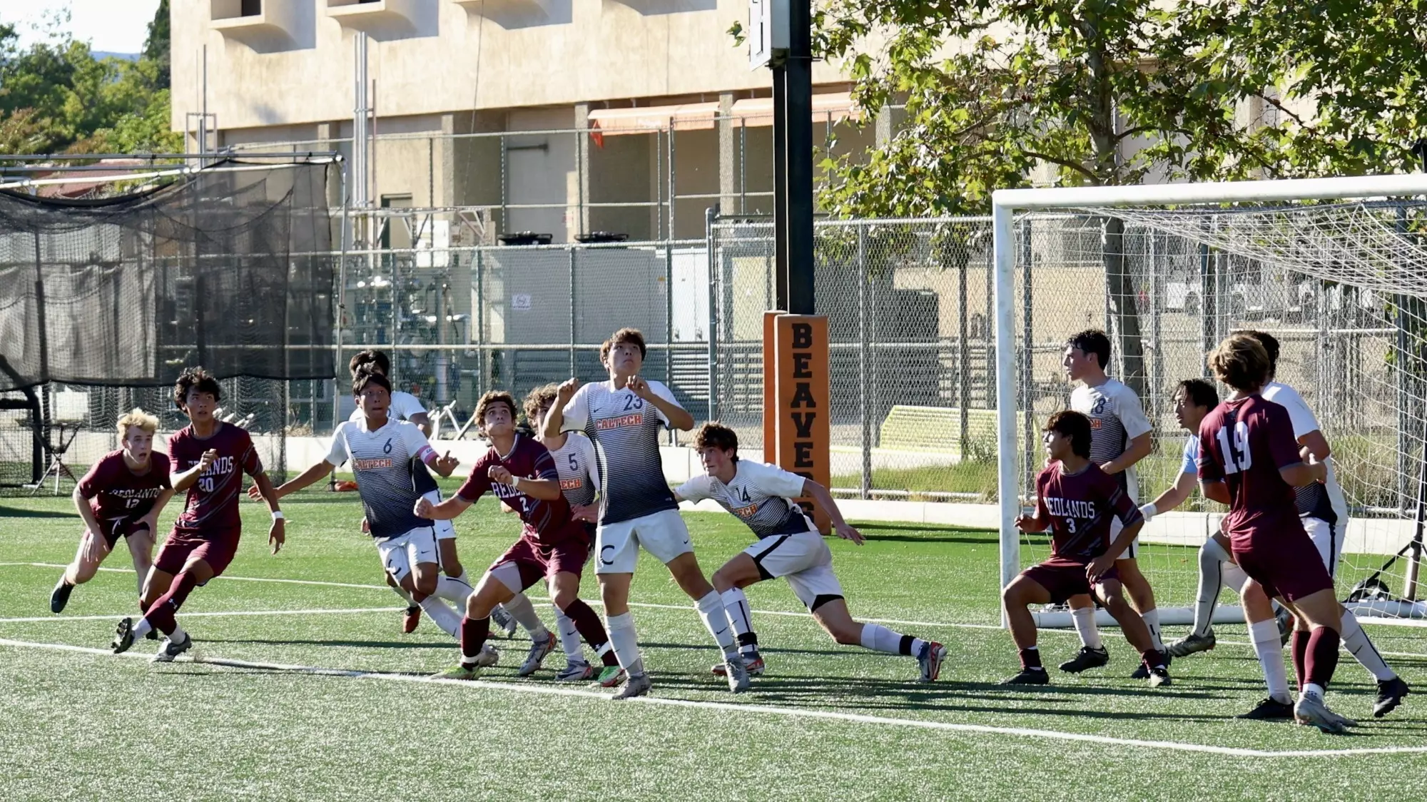 Caltech and Redlands men's soccer players jostle for position as a corner kick floats into the area