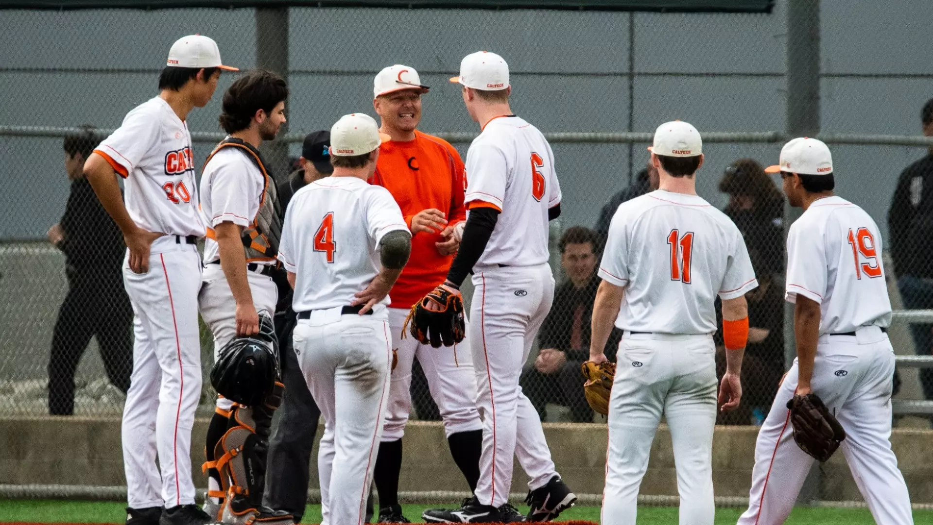 Head Coach Kevin Whitehead talks with Caltech Baseball players on the pitcher's mound