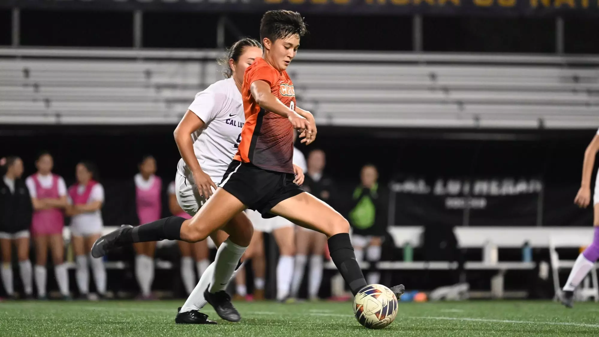 Choi-Schattle kicking ball past defenders 