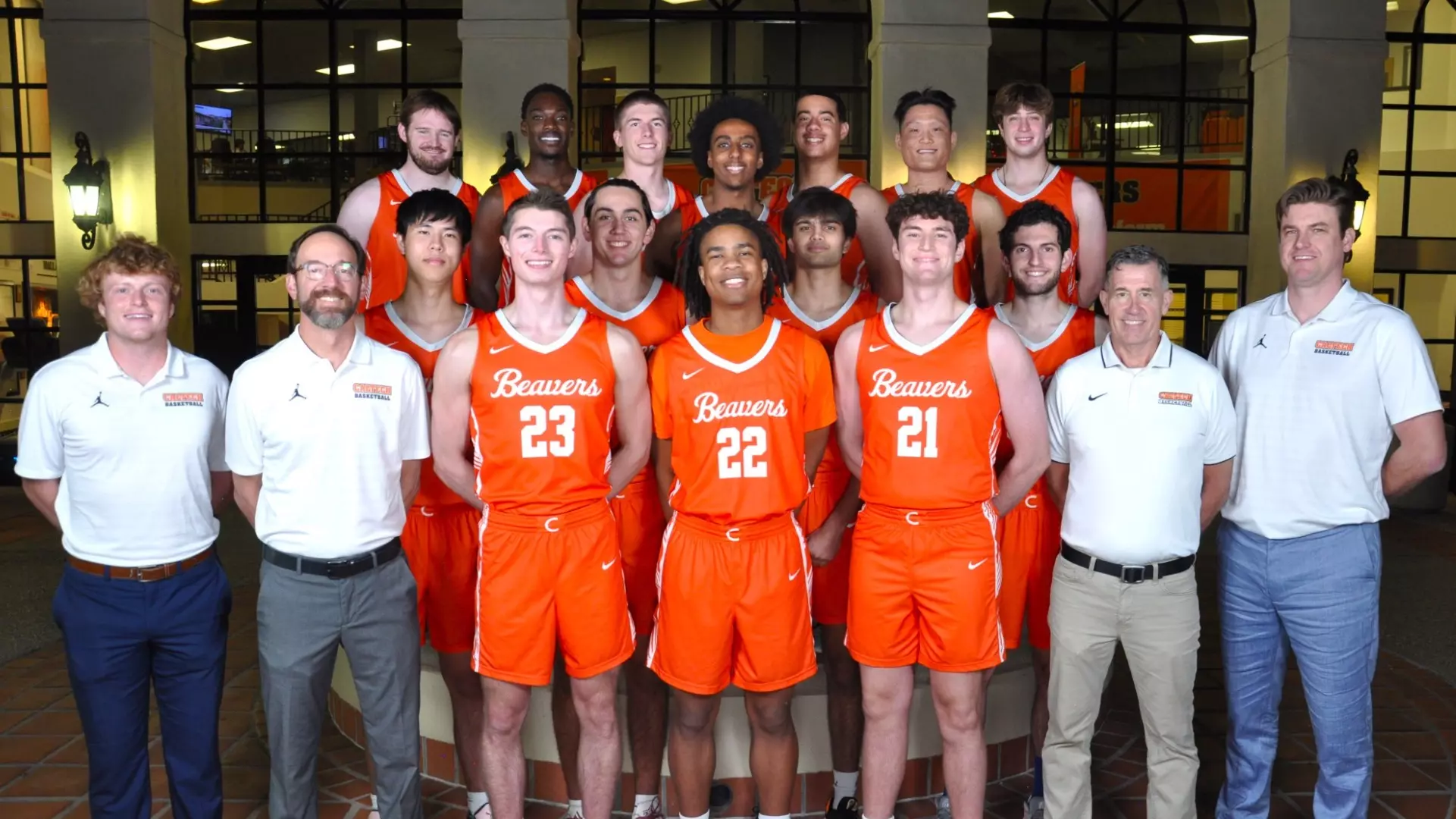 Photo of 2024-25 Caltech Men's Basketball team, including players and coaches, in front of the Braun Athletic Center