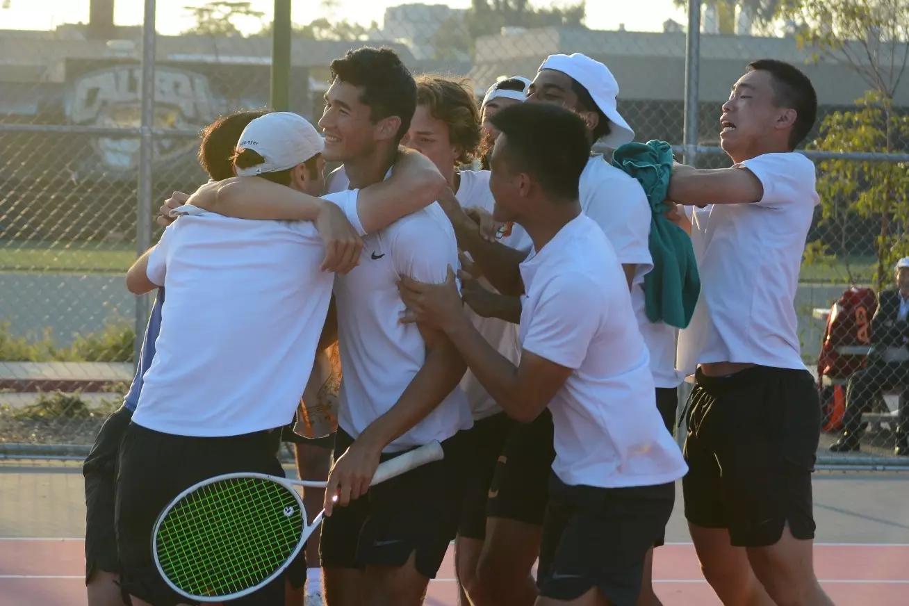 Caltech Men's Tennis Players surround Kyle McCandless in celebration of his Singles win and Caltech's dual match win over Johns Hopkins
