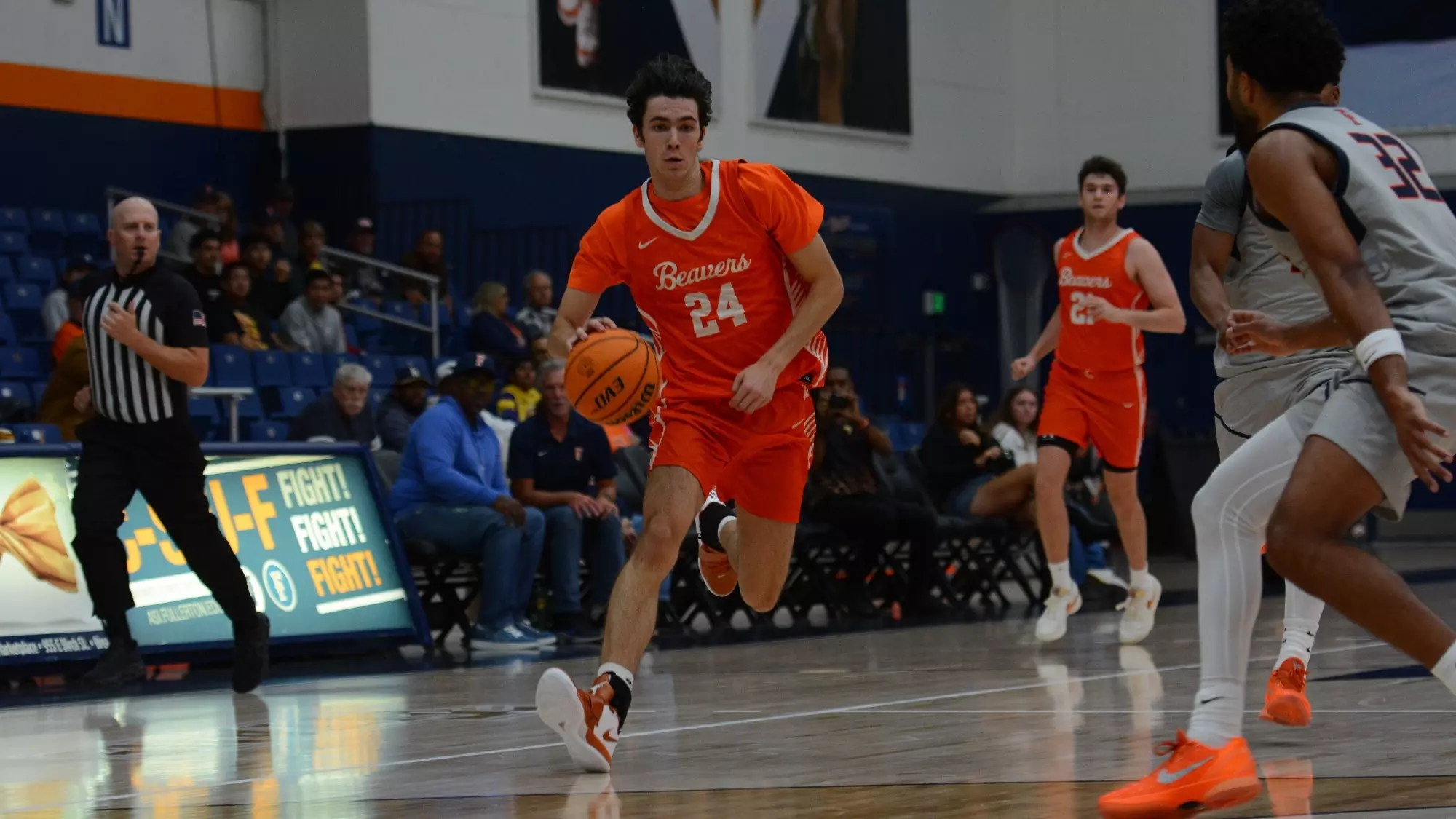 Dorian Glogovac Dribbles at a full sprint in transition on the right side of the court past a defender while controlling the ball in his right hand and beginning to lower his right shoulder. 