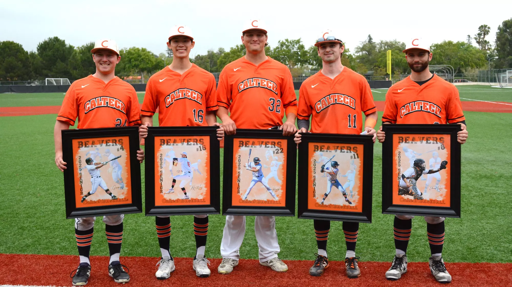 Garrett Knuf, Ryan Wong, Thorsen Kristufek, Jack Fishel and Edward Speer pose on the third base line while holding framed photos on Senior Day