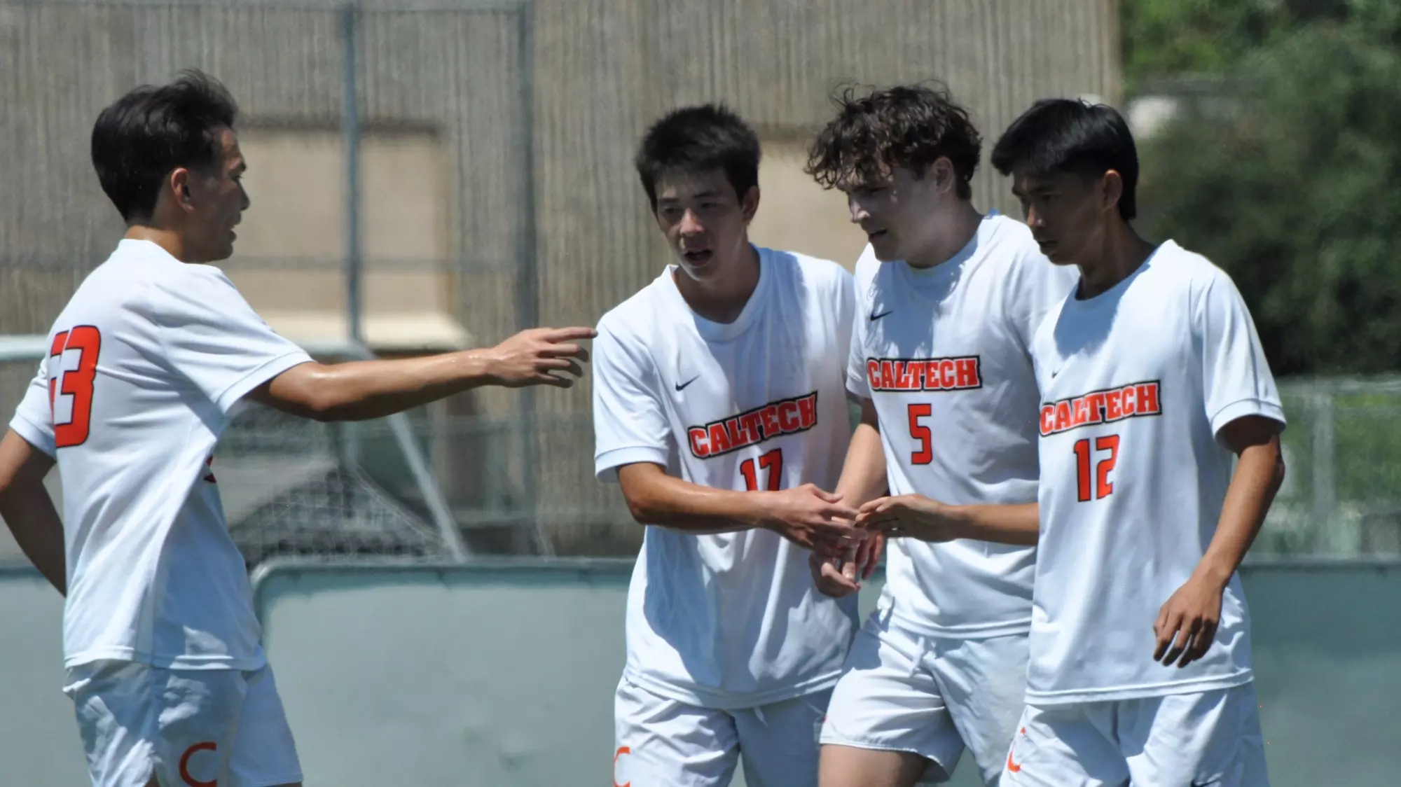 Caltech men's soccer teammates celebrate after scoring a goal