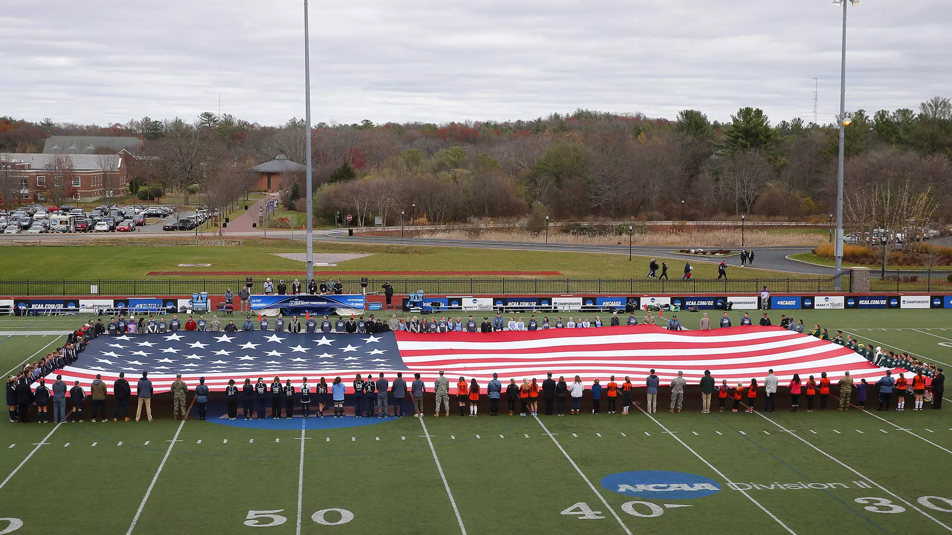 Teams and veterans hold the American flag before the game 