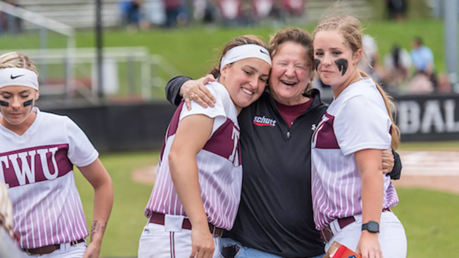 Dianne Baker celebrates with Texas Woman’s University softball players 