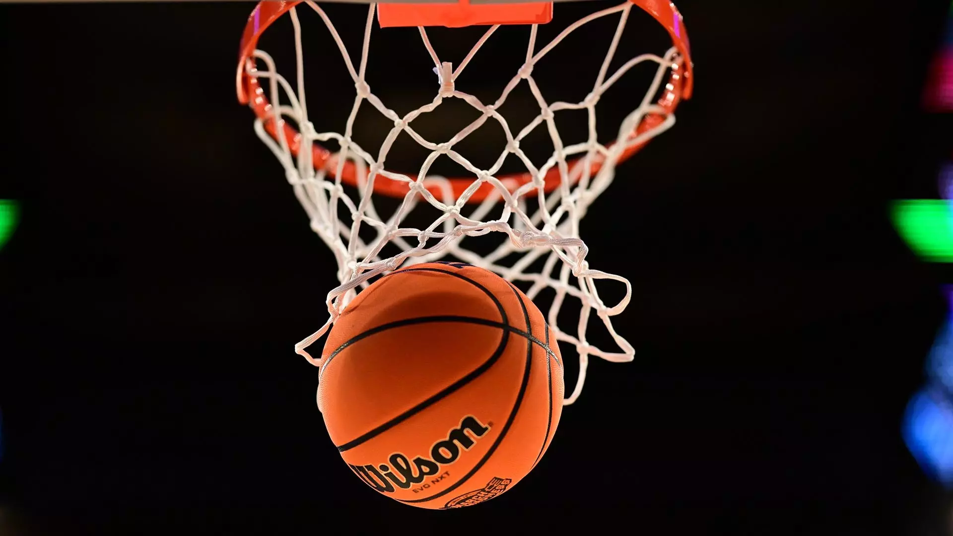 This is a picture of a basketball going through the basket.