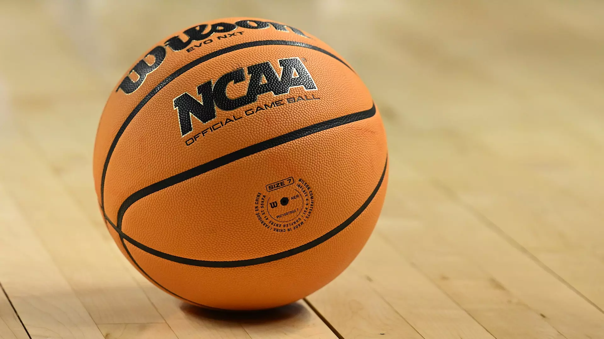 This is a photo of the new orange Wilson men's basketball at rest on the court.