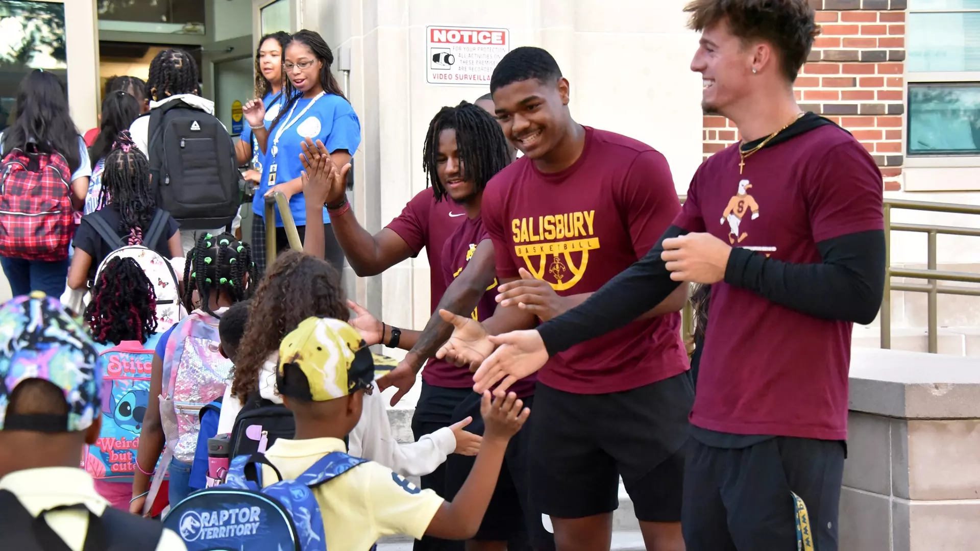 Salisbury men’s basketball players (from front) Reed Rebstock, Jordan Oates and Buddah Spencer greet Prince Street Elementary students on the first school day of the year.