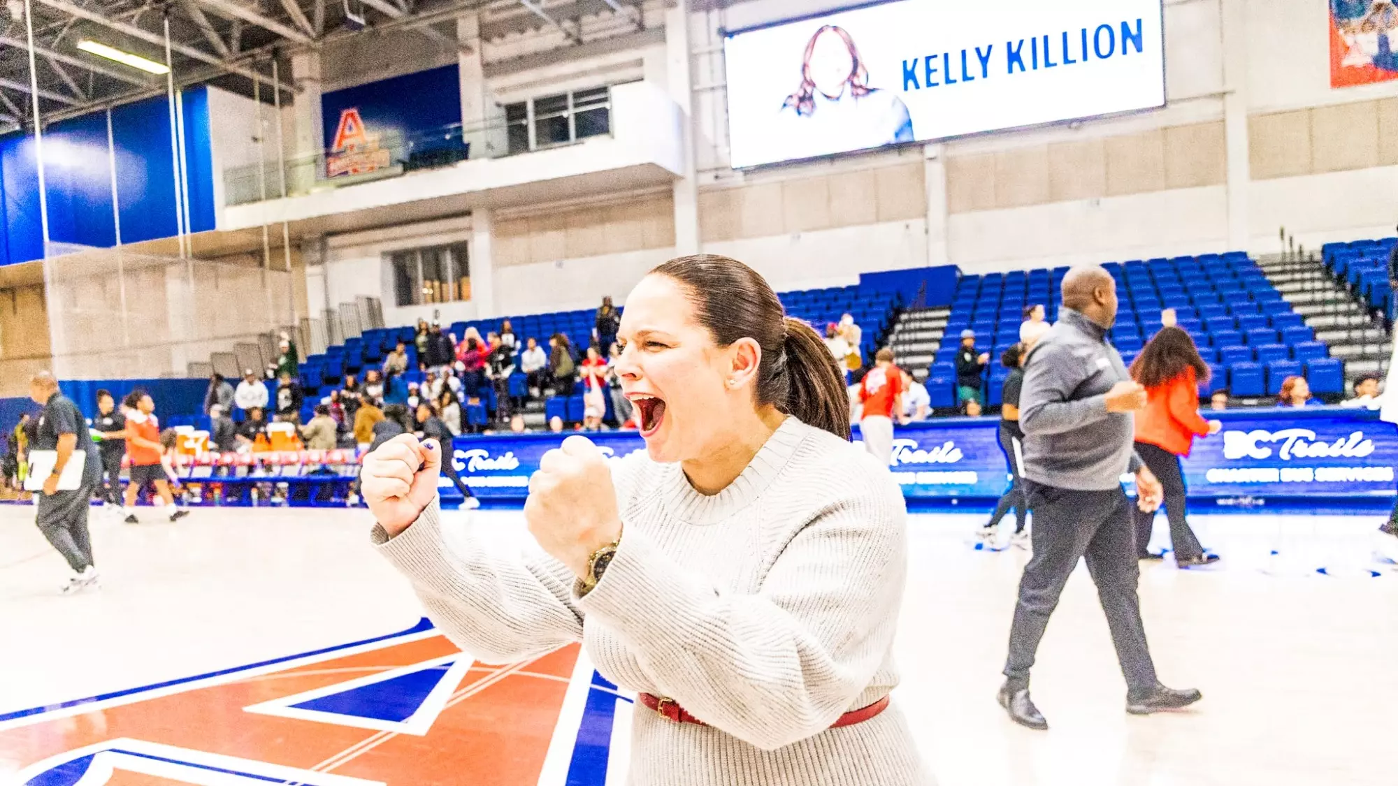 Kelly Killion celebrating on the court after her first win as head coach in the Eagles' season opener.