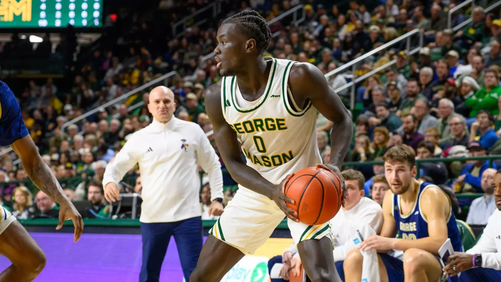 George Mason guard Masai Troutman drives during Homecoming week at EagleBank Arena