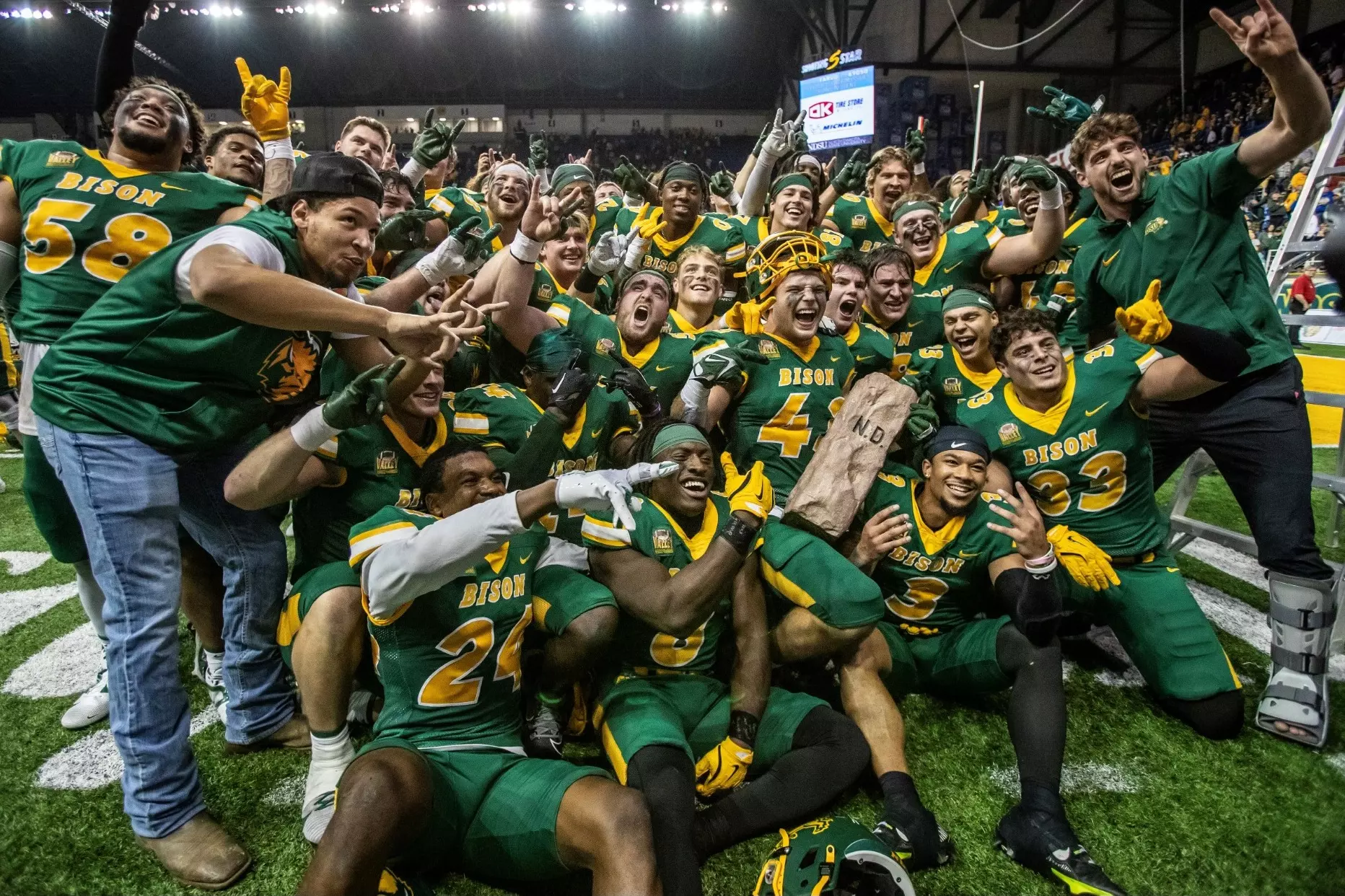 NDSU football players pose with the Dakota Marker