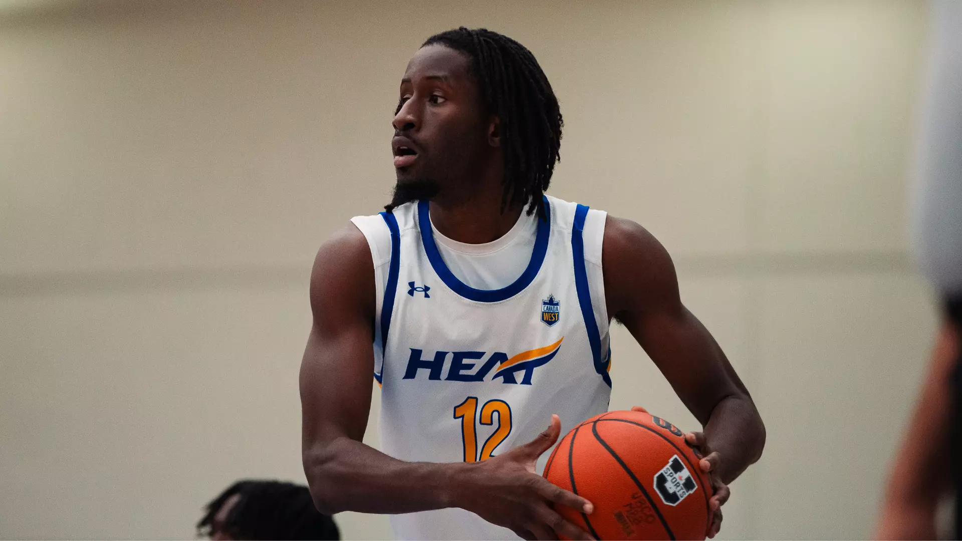 Lamine Conde of the UBCO mens basketball team holding ball looking to pass, stock