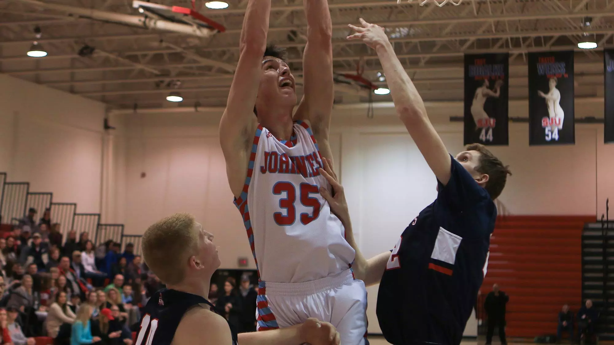 Lucas Walford goes up for a rebound between two Saint Mary's players