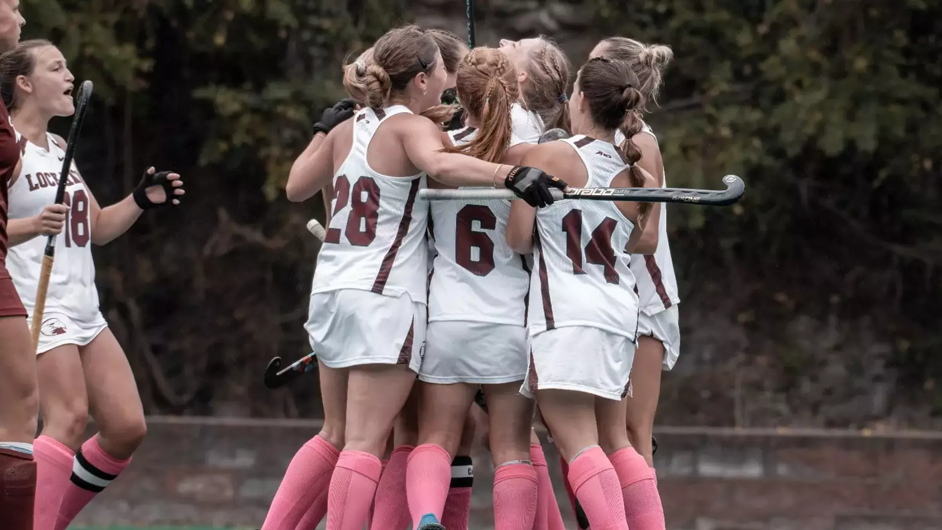 Field Hockey huddles in celebration following a goal