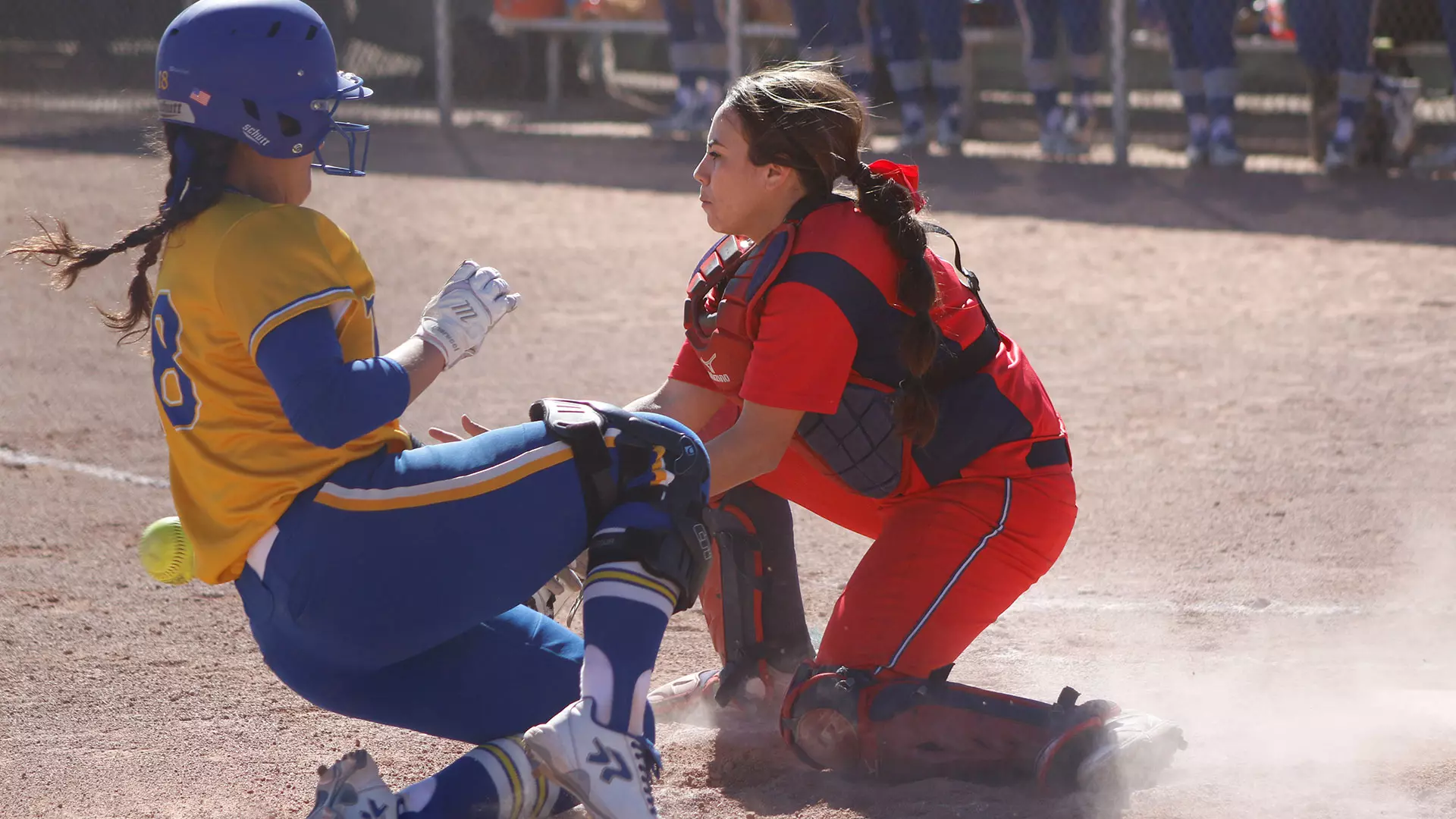 MSU Denver catcher at home plate with opponent sliding towards base