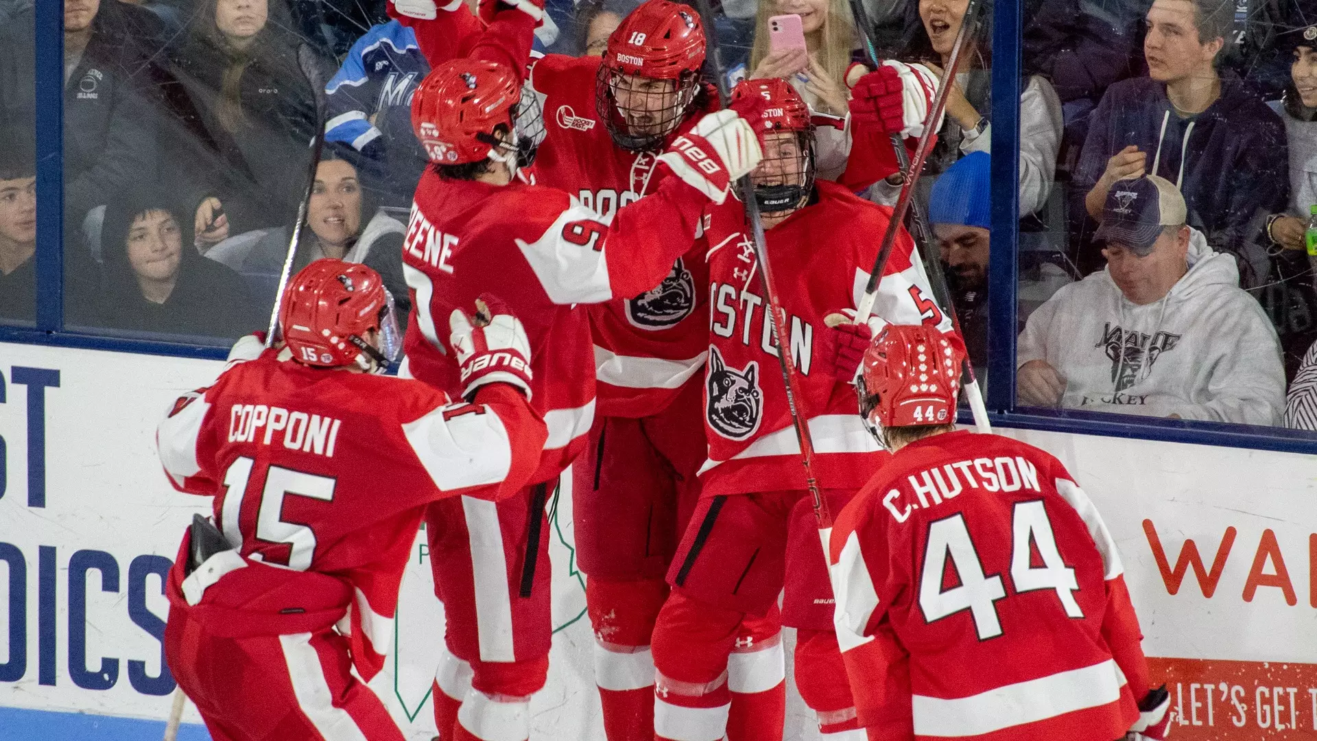 BU players celebrate with Shane Lachance after his tying goal at Maine