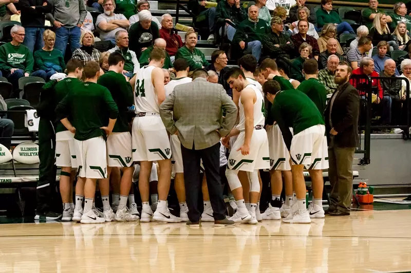 Illinois Wesleyan bench during a timeout