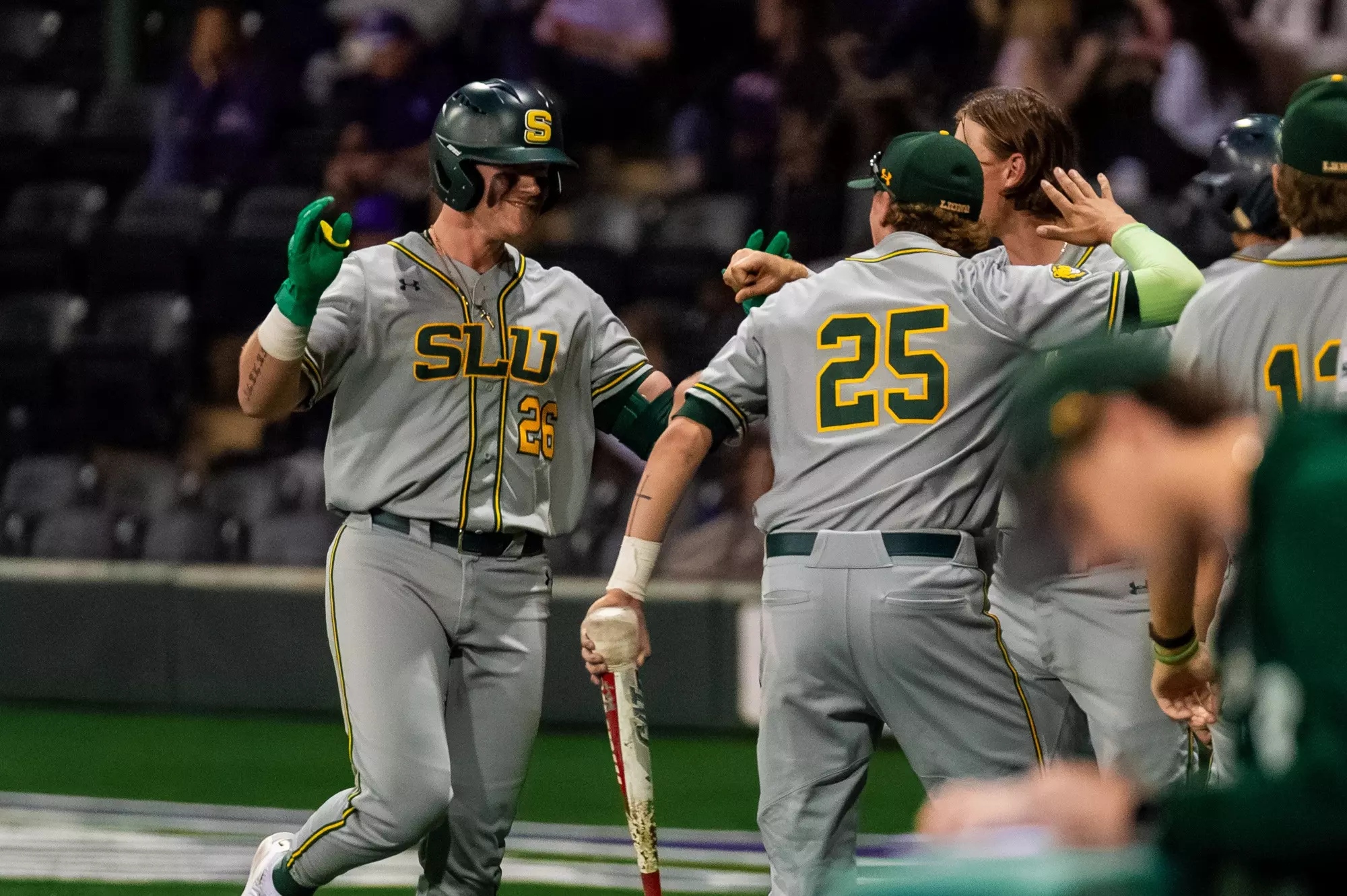 Blaise Priester receives congratulation from his teammates upon returning to the dugout following a sacrifice bunt.