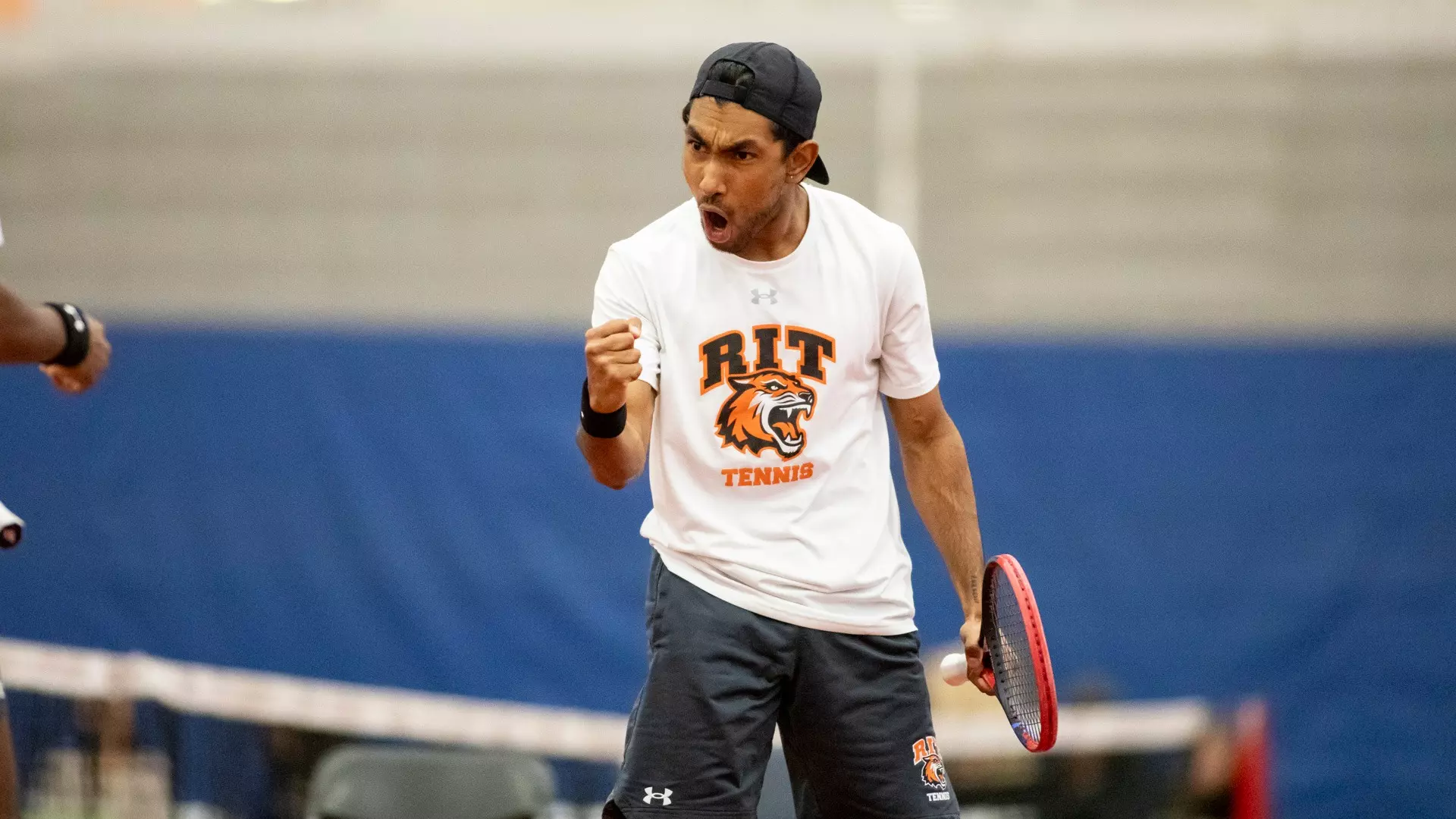 A men's tennis player celebrating after winning a point