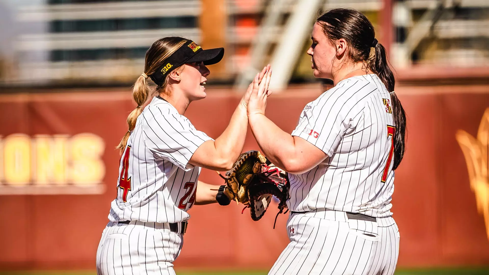 Bri Godfrey and Sydney Lewis celebrate in the circle following an out