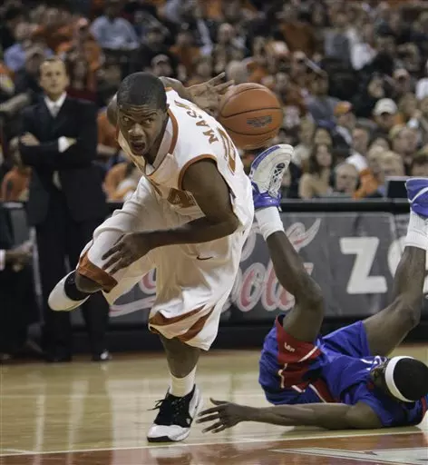 Texas guard Justin Mason, left, attempts a pass behind his back after taking the ball while fouling UT Arlington guard Rodrick Epps, right, during first-half action in a men's college basketball game Tuesday in Austin, Texas.  (AP Photo/Harry Cabluck)