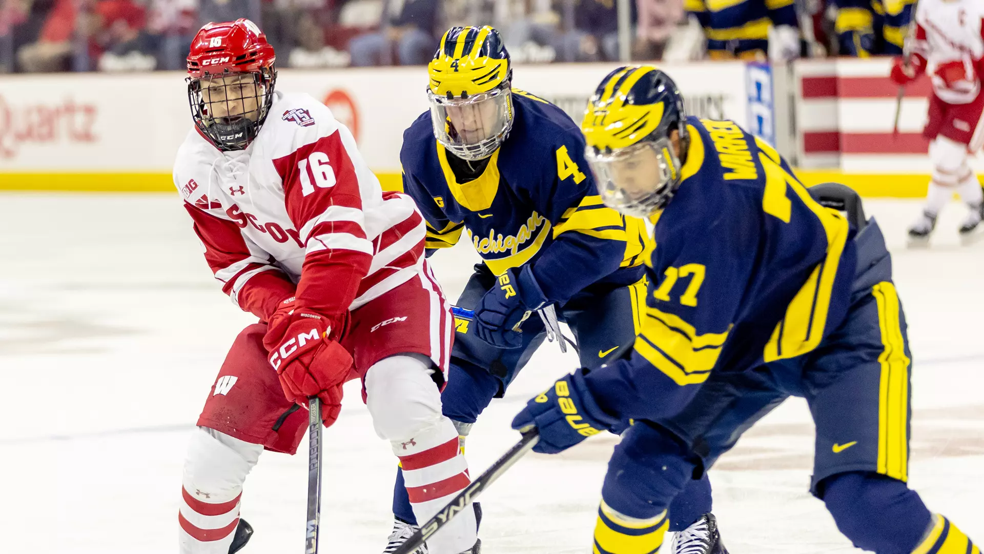 Tyson Dyck battles for the puck against two Michigan players.