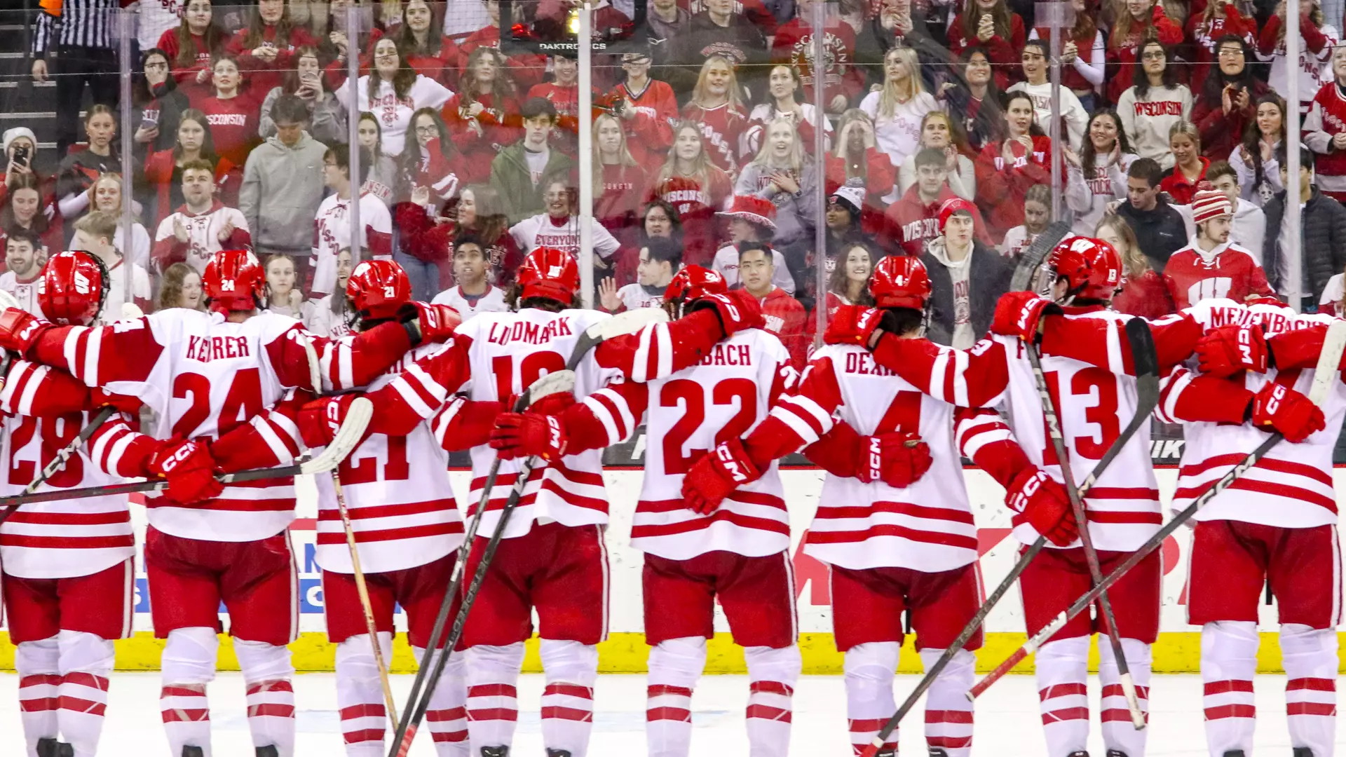 Badger men's hockey team celebrates a win with the student section at the Kohl Center