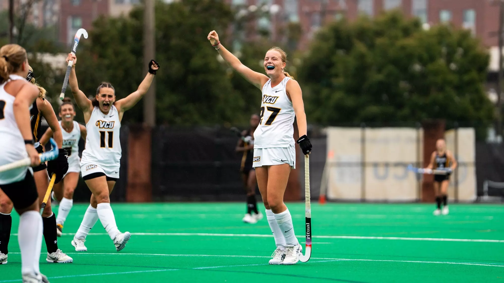 Julia Spohr of VCU wearing a white #27 jersey celebrates with her fist raised after scoring a goal against Towson