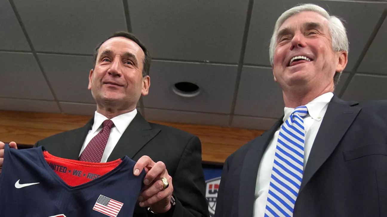 Duke University basketball coach Mike Krzyzewski, center, holds a Team USA jersey, as he is flanked by school President Richard Broadhead, left, and Director of Athletics Kevin White at a news conference in Durham, N.C., Thursday, May 23 2013. Krzyzewski is back as the U.S. men's national team coach and ready for another run at Olympic gold. (AP Photo/The News & Observer, Corey Lowenstein)  MANDATORY CREDIT