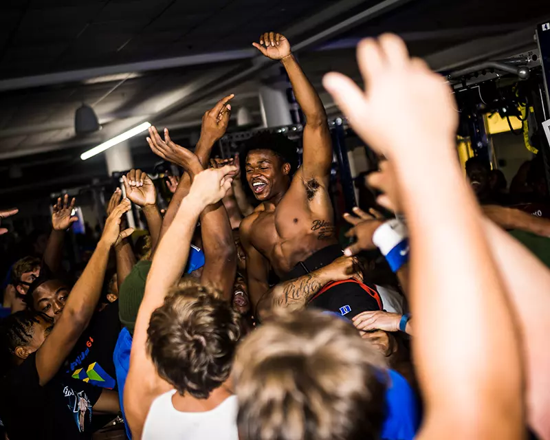 Members of the Duke football team celebrate after a workout
