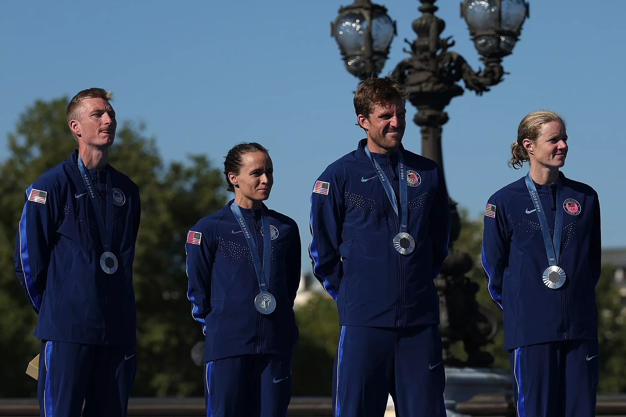 PARIS, FRANCE - AUGUST 05: Silver medalists Seth Rider, Taylor Spivey, Morgan Pearson and Taylor Knibb of Team United States celebrate the podium during the Triathlon medal ceremony after the Mixed Relay on Day Ten of the Olympic Games Paris 2024 at Pont Alexandre III on August 05, 2024 in Paris, France. (Photo by Al Bello/Getty Images)