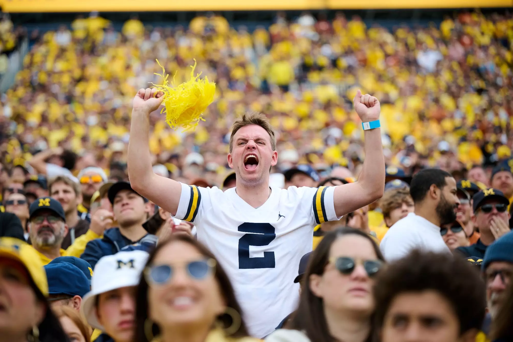 Michigan Football Fan Cheering at Michigan Stadium in a crowd of people