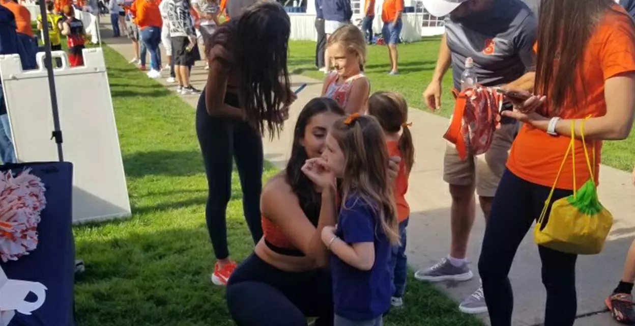 Dance team doing face paint at 'Cuse on the Quad