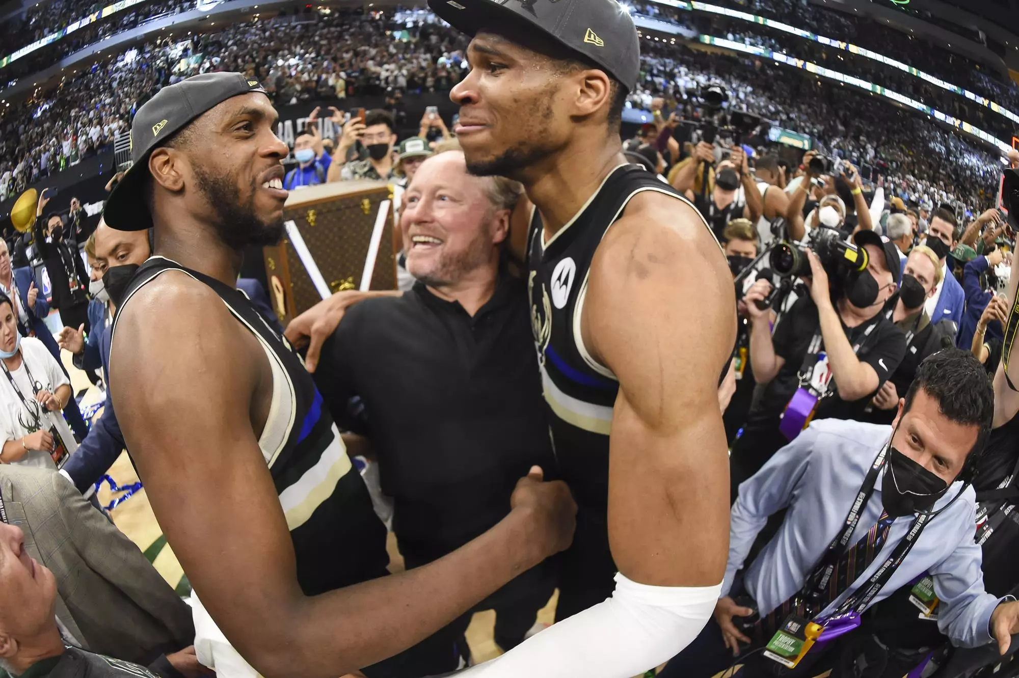 MILWAUKEE, WI - JULY 20: Giannis Antetokounmpo #34 of the Milwaukee Bucks hugs Khris Middleton #22 of the Milwaukee Bucks and Head Coach Mike Budenholzer of the Milwaukee Bucks after defeating the Phoenix Suns in Game Six to win the 2021 NBA Finals on July 20, 2021 at the Fiserv Forum in Milwaukee, Wisconsin. NOTE TO USER: User expressly acknowledges and agrees that, by downloading and or using this Photograph, user is consenting to the terms and conditions of the Getty Images License Agreement. Mandatory Copyright Notice: Copyright 2021 NBAE (Photo by Andrew D. Bernstein/NBAE via Getty Images).