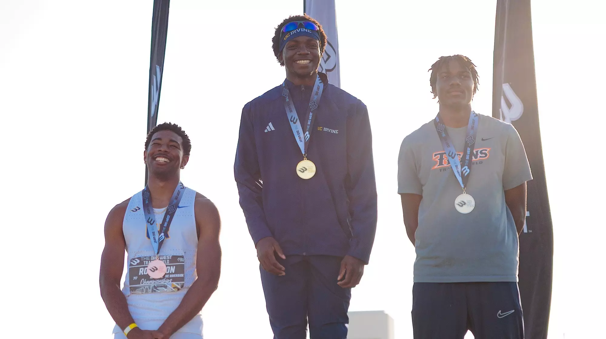 Kenechukwu Okonkwo of UCI men's track & field stands at the top of the podium after winning the triple jump at the Big West Championships.