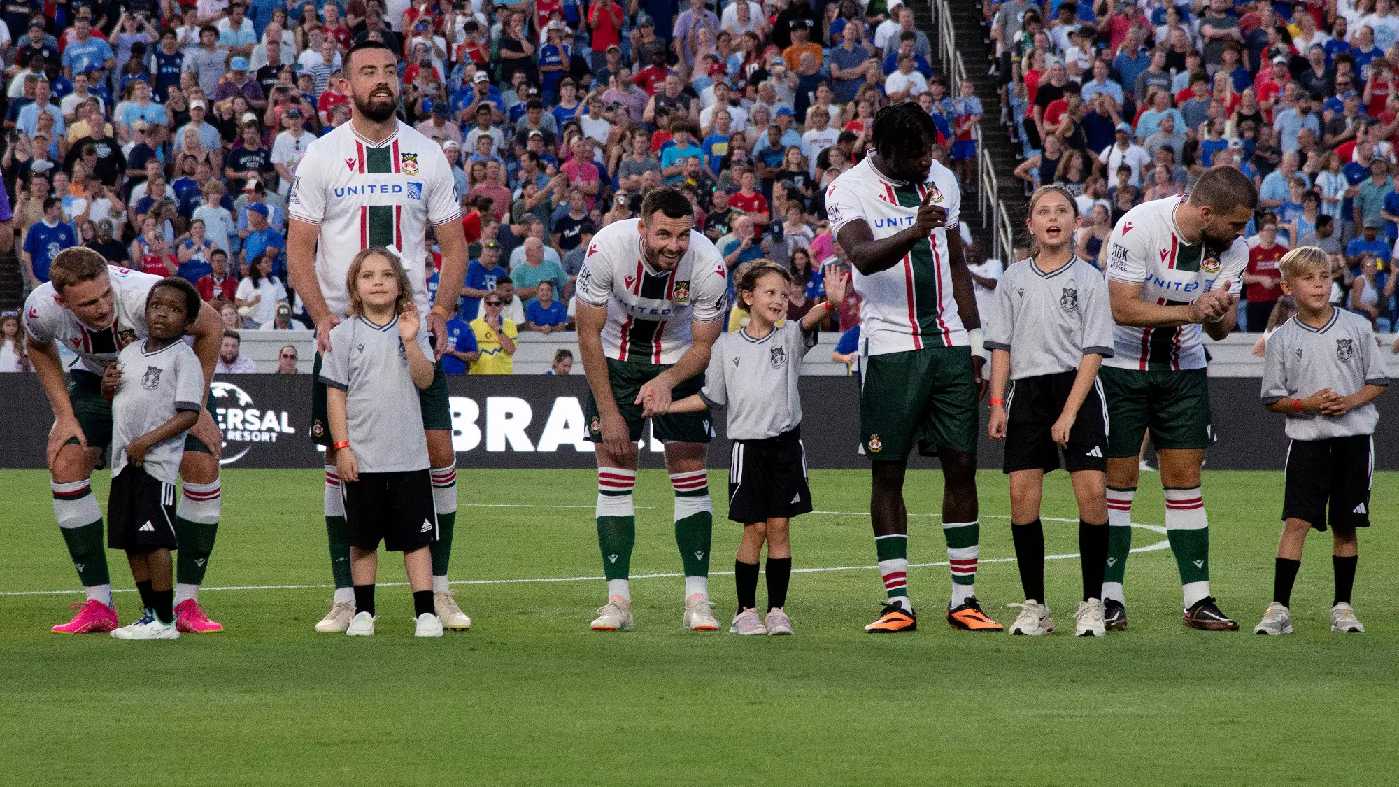 Young children and the Wrexham players interact during team introductions.