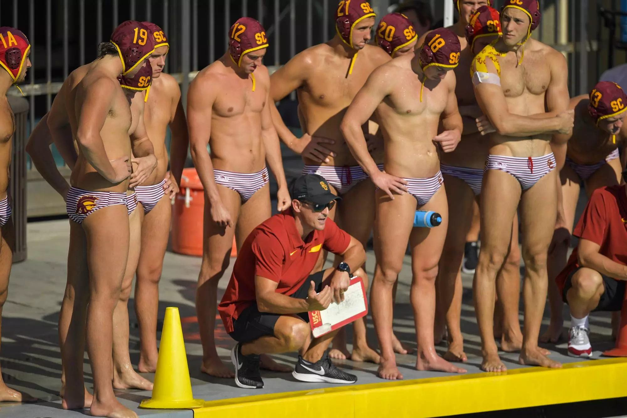 MArko Pintaric crouching surrounded by men's water polo team