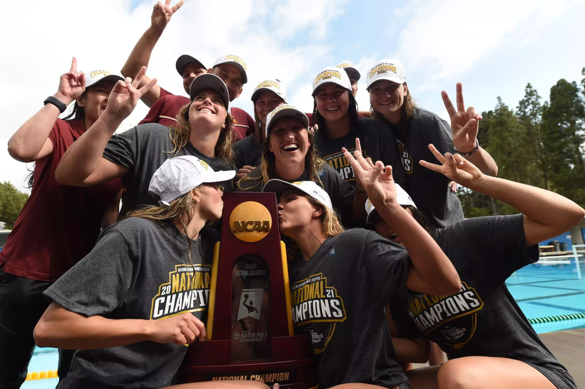 Women's water polo holding NCAA trophy