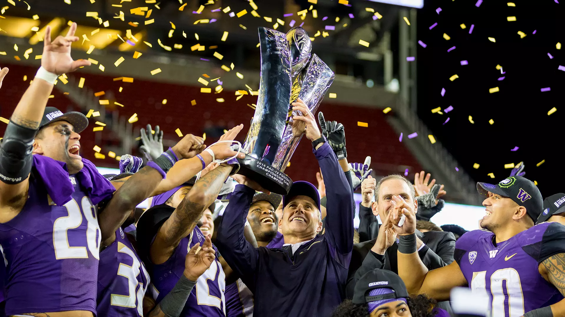 Chris Petersen holds the 2016 Pac-12 Championship trophy following the win over Colorado