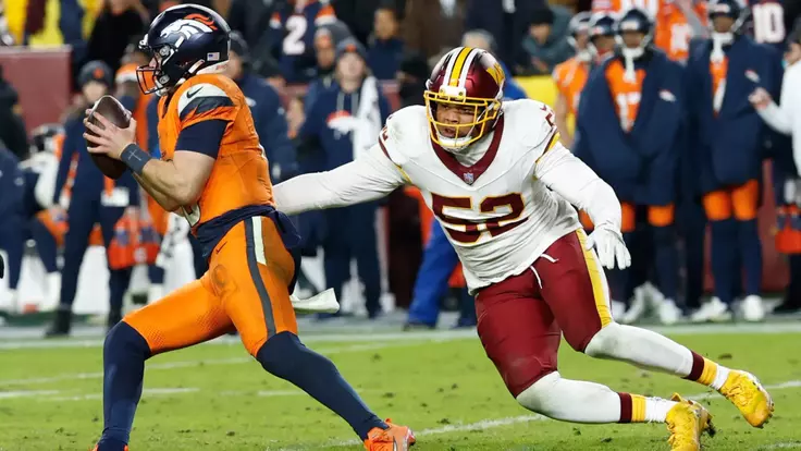 Nov 30, 2025; Landover, Maryland, USA; Denver Broncos quarterback Bo Nix (10) scrambles with the ball under pressure from Washington Commanders linebacker Preston Smith (52) in the fourth quarter of the game at Northwest Stadium. Mandatory Credit: Geoff Burke-Imagn Images
