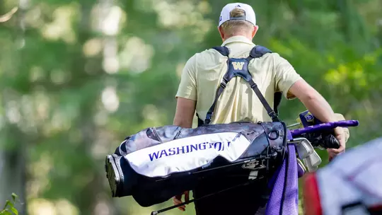 Finn Koelle carries bag during round