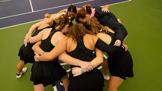 Women's tennis huddles as a team prior to match against Portland