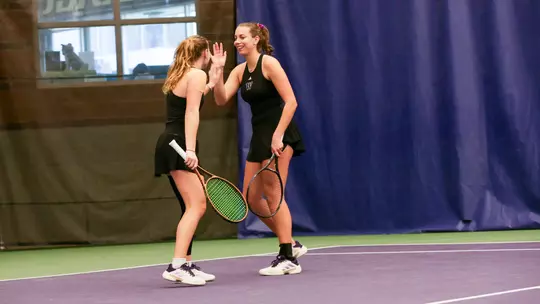 Marie Weissheim and Alexia Jacobs high fave during doubles against UCSB