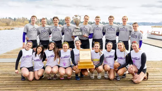 The UW senior men's crew and freshman women's crew pose for a photo with their trophies after having won their races at the 2026 Class Day Regatta.